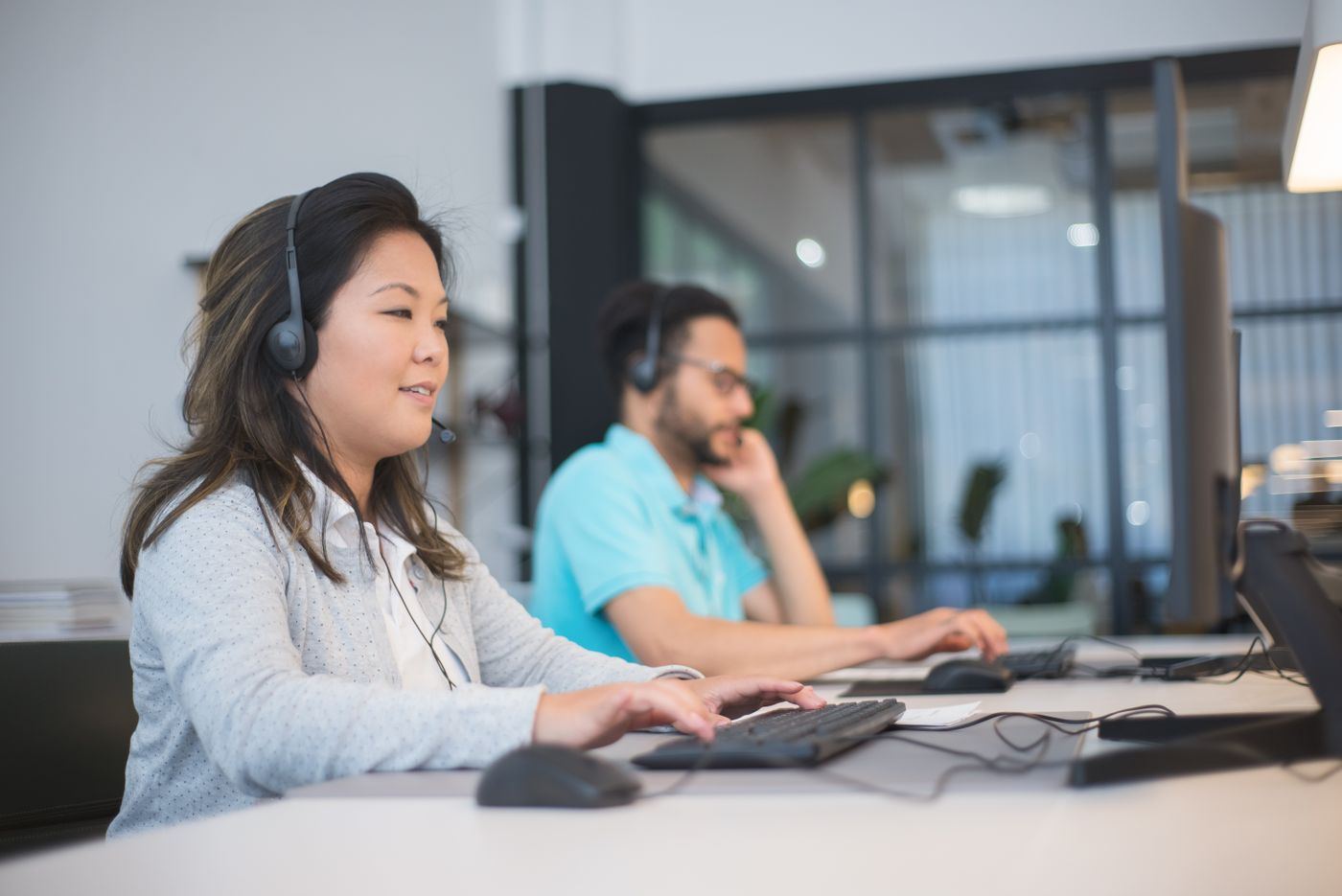 Two members of the team on calls at their desks